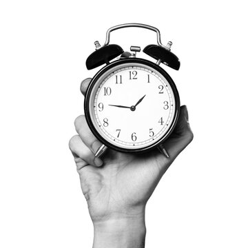 A person holds up a clock in one hand. The clock has an alarm feature and displays numbers clearly. The background is transparent, making the clock stand out.