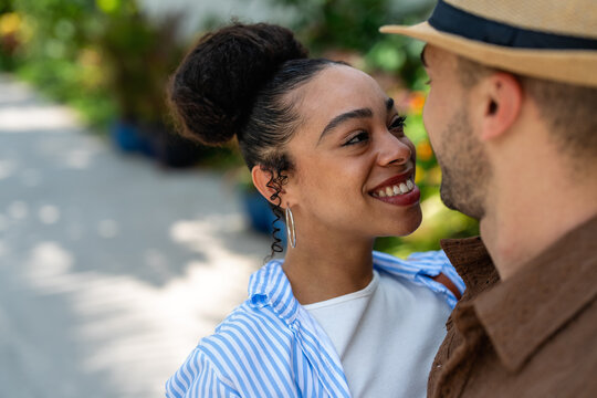 Diverse couple sharing a laugh while exploring a tropical paradise together on summer vacation