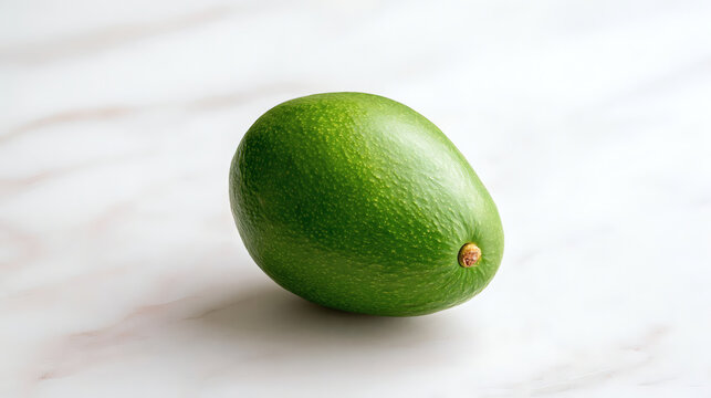 Fresh whole green avocado on a light marble background. Minimalist composition, healthy eating, organic fruit, copy space, close-up.