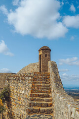 The historic stone walls and lookout tower of Marvão Castle under a bright blue sky, Portugal. © Marco