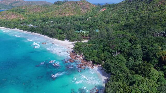 Aerial view of Anse Lazio beach with turquoise water, white sand, and lush tropical vegetation in Baie Sainte Anne, Seychelles.