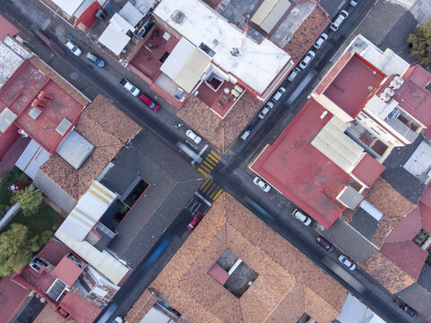 Aerial view of the historic Centro district in Uruapan, featuring terracotta rooftops, narrow streets with parked cars, and urban architecture in Uruapan, Michoacan, Mexico.