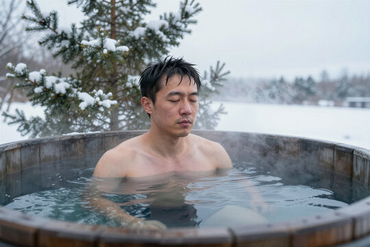 Man sitting shoulder deep in snowy outdoor cold plunge