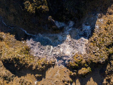 Aerial view of the rugged volcanic terrain of Gunung Sumbing Wonosobo with rocky slopes and sparse vegetation in Kecamatan Kalikajar, Jawa Tengah, Indonesia.