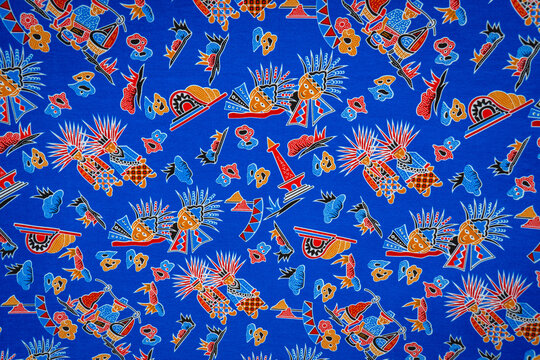 Betawi batik fabric featuring colorful cultural motifs on a vivid blue background with red, orange, yellow, and light blue details.