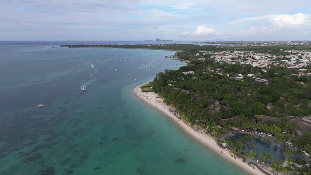 Aerial view of Trou aux Biches Beach with turquoise water, white sand, and lush greenery along the coastline of Pamplemousses District, Mauritius.