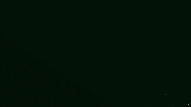 Green glowing oval shape illuminating dark space with white dots