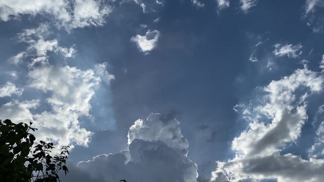 Movement of Beautiful dark rain storm clouds reveals the sun, thunderstorm in dramatic sky, with lens flare. Climate cloudscape scenic. Weather tropical summer squall.