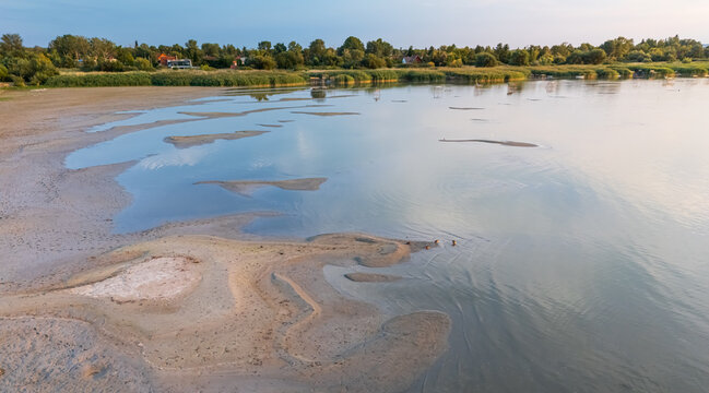 Aerial view of drought-hit Lake Balaton shore with reeds and piers in summer