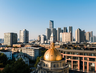 A historic golden-domed building in Wuhan stands in striking contrast to modern towering skyscrapers, beautifully illustrating the city's dynamic evolution from its rich heritage to a vibrant future. © 晨啸 周