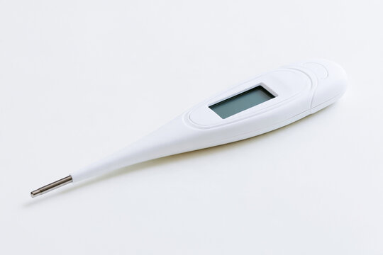 Digital thermometer with a blank display on a white surface, fever and temperature concept