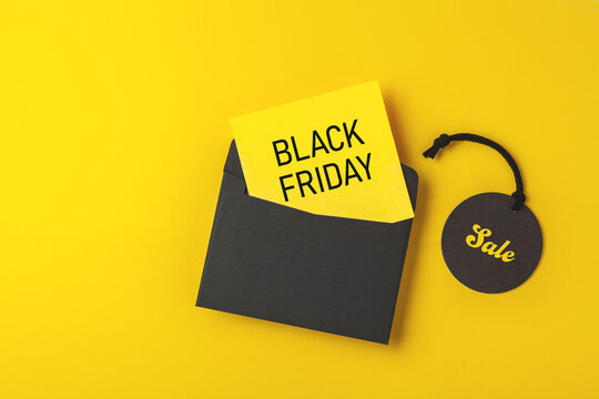 Black Friday Sale concept, black price tag, yellow card with envelope on yellow background
