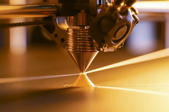 3D printer nozzle laying down a fine filament layer, additive manufacturing detail