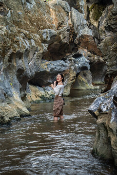 Asian Woman Standing in Stream Inside Klong Hin Dum Black Stone Canyon with Dramatic Eroded Rock Formations at Khao Khai Sawi District Chumphon Thailand