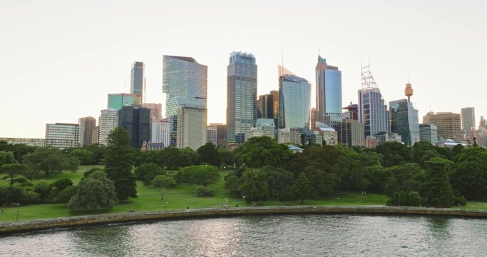 Aerial view of the modern skyline featuring glass skyscrapers and the Sydney Tower rising above the Royal Botanic Garden and harbor waters Sydney, New South Wales, Australia.