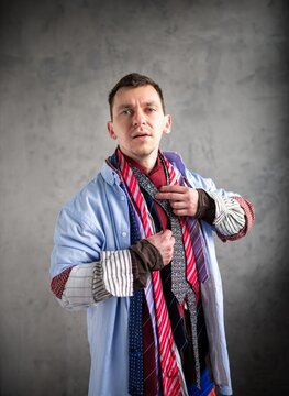 Young man adjusting one of many ties around his neck