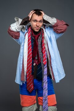 Stressed man in multiple layers of clothing holding his head