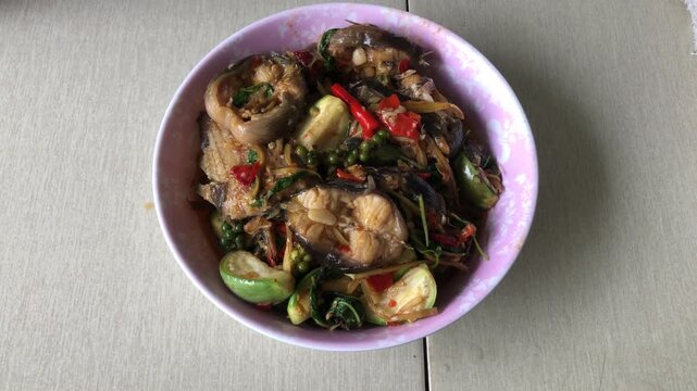 Spicy stir-fried catfish with various herbs and green eggplant, delicious and healthy dish.