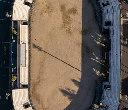 Aerial view of the Feria Ganadera featuring an oval track and tiered seating with long shadows cast by stadium lights in Santo Domingo, Distrito Nacional, Dominican Republic.