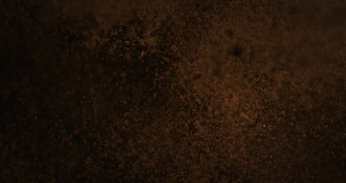 Top-down view of soil and dust erupting in a powerful explosion against a dark background, captured in super slow motion. Cinematic abstract action with dramatic texture and movement.