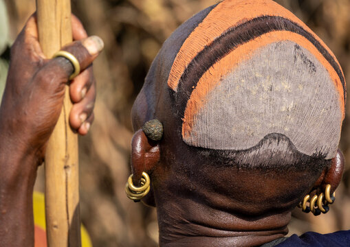 Dassanech man with stick and clay hair cap, Omorate, Ethiopia