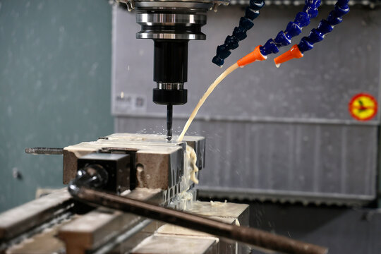 CNC milling machine working with coolant fluid in a modern industrial manufacturing workshop