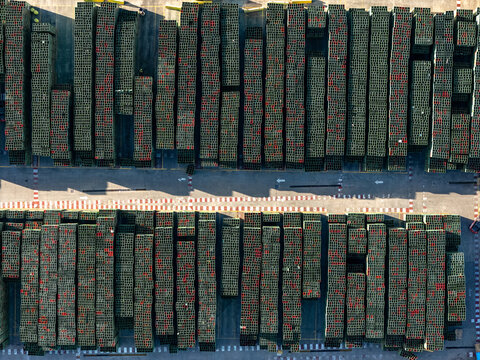 Aerial view of a beer industrial complex with organized rows of stacked plastic crates on a paved yard in Santo Domingo, Dominican Republic.