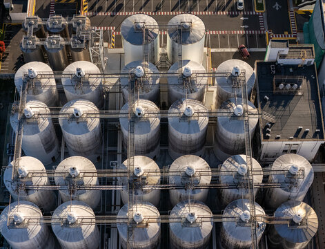 Aerial view of the beer industrial complex with rows of large metal storage tanks and connecting catwalks in Santo Domingo, Dominican Republic.
