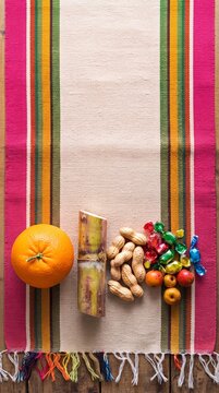 Traditional Las Posadas items on a colorful Mexican blanket  