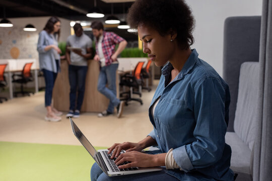 Black woman using laptop in creative workplace