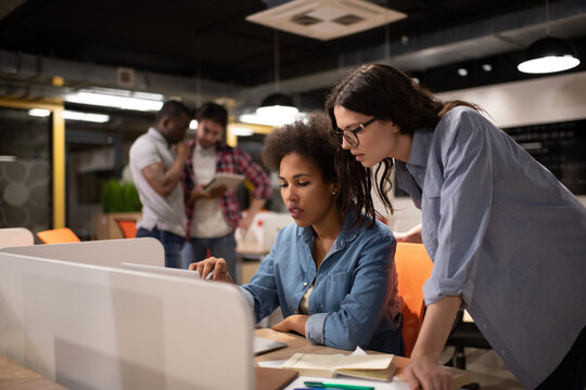 Diverse female colleagues working on project together during meeting