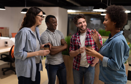 Cheerful black woman discussing project with colleagues during break