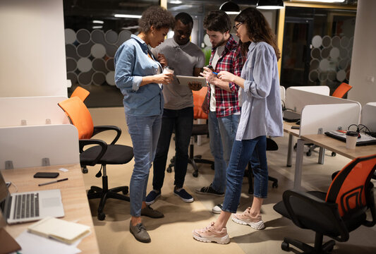 Diverse colleagues using tablet in modern workplace