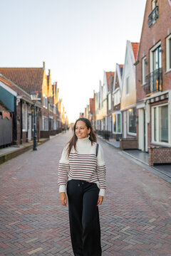 Woman walking through a fishing village in the Netherlands.