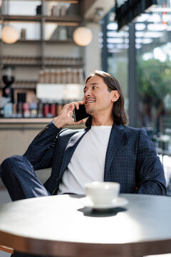 Man in cafe, on phone, with coffee