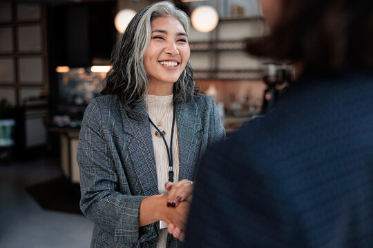 Smiling woman shakes hands in a business setting