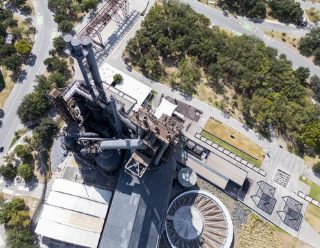 Aerial view of the industrial structures at Fundidora Park and the Paseo de la Mujer pathways surrounded by lush trees in Monterrey, Nuevo Leon, Mexico.