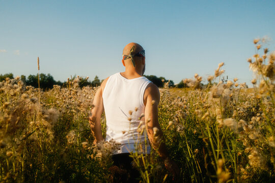 Man Walking Through a Field of Flowers in the Late Afternoon