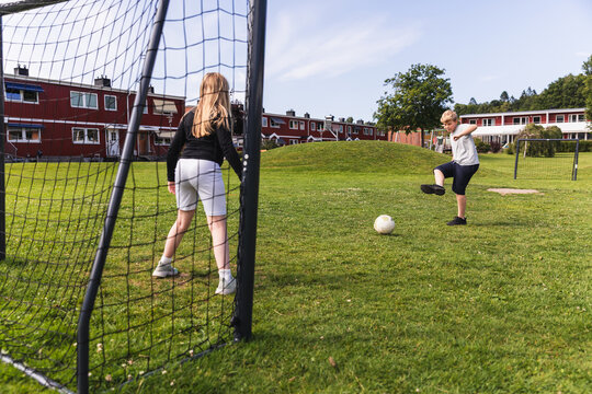 Kids playing soccer penalty shootout in neighborhood park