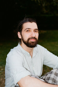 Man Sitting on Grass in a Park During Evening Time
