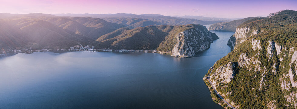 Aerial view of the Danube River shaping the dramatic Iron Gates gorge with steep cliffs and green mountains under a purple sky