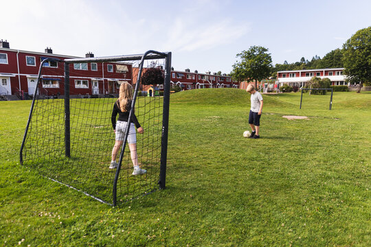 Kids playing soccer penalty shootout in neighborhood park