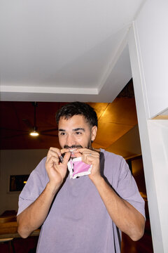 UGC Man fitting clear dental aligner on teeth during home routine