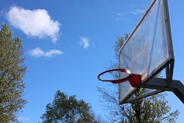 Street basketball hoop with transparent backboard under blue sky and sunlight, sports and recreation concept © Алина Неборская