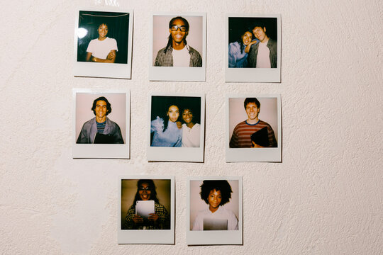 Instant analog portraits of a diverse young team taped to a wall.