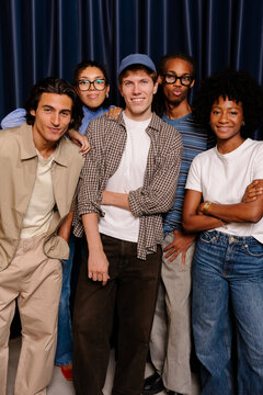 Diverse team of office workers posing and hugging together.