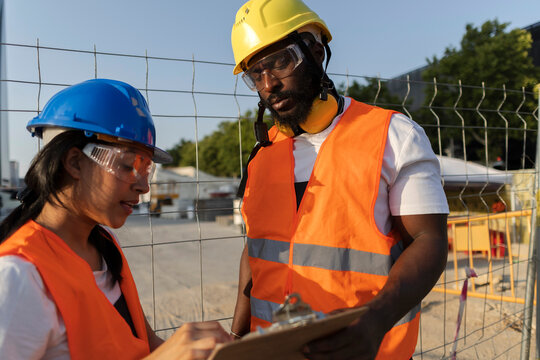 Diverse construction team collaborating on project site inspection
