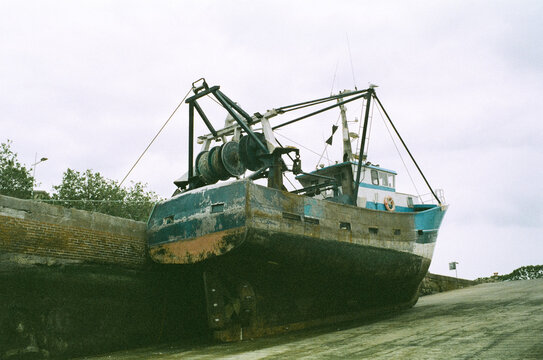 Old fishing trawler beached at a harbour wall