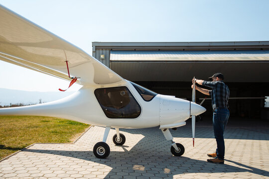 Pilot Performing Preflight Check On Small Plane