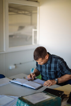 Pilot Doing Flight Planning With Logbook and Map
